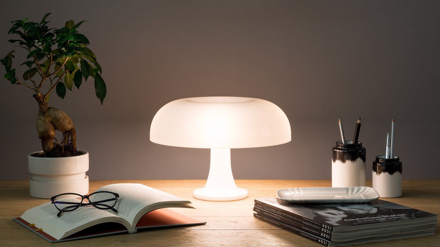 Lampada da tavolo di design accesa su una scrivania in legno