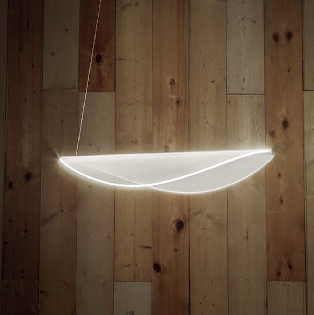 Sospensione lineare a LED su una parete rivestita in legno